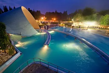 The shell-shaped pool lit up in the evening
